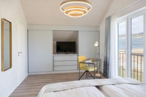 a bedroom with a bed and a desk with a television at Ferienhaus Neukamp 17E Robbenhütte in Putbus