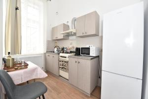 a kitchen with white cabinets and a table and a microwave at BLISS HOUSE Primariei in Oradea