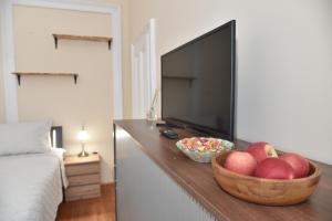 a room with a bowl of apples and a television at BLISS HOUSE Primariei in Oradea