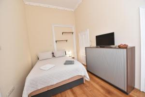a small bedroom with a bed and a television at BLISS HOUSE Primariei in Oradea