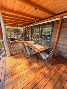 a wooden deck with a table and chairs on it at George Holiday Homes - Soline Beach in Biograd na Moru