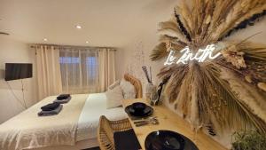 a bedroom with a bed with a table and a sign at Le zénith vieille ville d'Annecy in Annecy