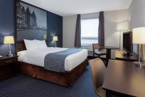 una camera d'albergo con un letto e una scrivania di Super 8 by Wyndham Lachenaie/Terrebonne a Terrebonne