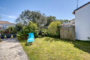 ein blauer Stuhl, der im Gras im Hof sitzt in der Unterkunft 339 - La Balinaise - Villa with pool in Sainte-Marie-de-Ré