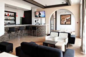 a bar in a room with couches and chairs at Poseidonio Hotel in Tinos