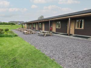 a row of lodges with picnic tables in front of them at Cherry in Cowbridge