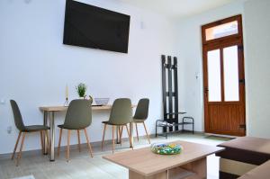 a living room with a table and chairs and a tv at Mid Centro Residence, Self check in & out in Oradea