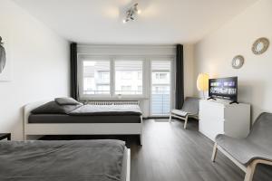 a bedroom with two beds and a television in it at VAZ Apartments Freiheit 2 für Monteure, Küche, TV, WLAN, Balkon in Remscheid