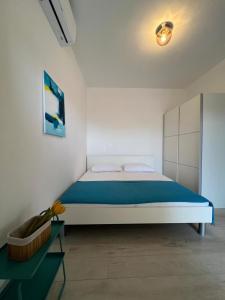 ein Schlafzimmer mit einem Bett in einem weißen Raum in der Unterkunft Apartments Sunset Dolac in Primošten