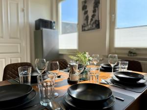 a table with plates and glasses on top of it at TT Living Apartments BONITAS & DIVINITAS I 2 Schlafzimmer I Küche I Vollbad I Waschmaschine in Rellingen