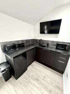 Una pequeña cocina con fregadero y microondas. en Hornby Hottub and Jacuzzi Suites, en Blackpool