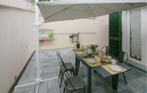 a table with chairs and an umbrella on a patio at 3 Bedroom Nice Home In Ripa in Vallecchia +20 photos