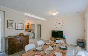 a dining room with a table and a clock on the wall at 3 Bedroom Nice Home In Ripa in Vallecchia
