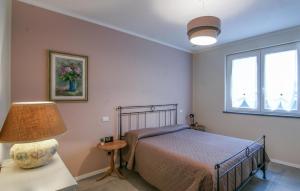 a bedroom with a bed and a lamp and two windows at 3 Bedroom Nice Home In Ripa in Vallecchia