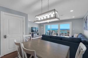 ein Wohnzimmer mit einem Tisch und einem Sofa in der Unterkunft Once Upon A Tide by Gulf Coast Getaways in Navarre