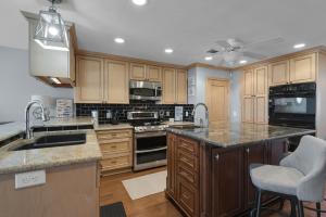 eine Küche mit Holzschränken und Geräten aus Edelstahl in der Unterkunft Once Upon A Tide by Gulf Coast Getaways in Navarre + 31 Fotos