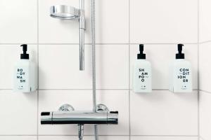 un bagno con lavandino e bottiglie di sapone sul muro di Scandic Linköping City a Linköping
