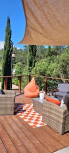 eine Holzterrasse mit Stühlen und einem karierten Teppich in der Unterkunft Les Cyprès de Chaume in Vidauban