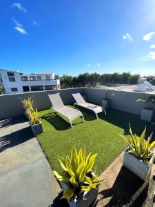a patio with chairs and grass on a roof at Appartement avec Rooftop privé et Jacuzzi in Albion