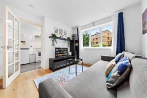 a living room with a couch and a television at City Flat with a master size bed in London