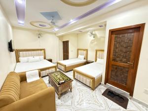 a living room with two beds and a couch at Serene Elegance Hotel in Islamabad +59 photos
