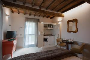 a bedroom with a bed and a desk and a mirror at Cattania Suites and Rooms in Campogalliano