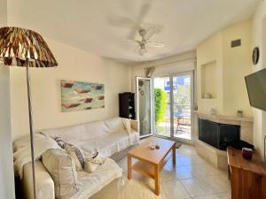 Una sala de estar con un sofá blanco y un televisor. en Nikiti Azzurro villa, en Nikiti