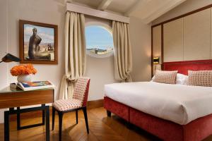 a hotel room with a bed and a desk and a window at Hotel Balestri - WTB Hotels in Florence