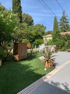 a garden with a table and chairs and a potted plant at chambre d'hôtes villa tigre LA CIOTAT Quartier résidentiel in La Ciotat