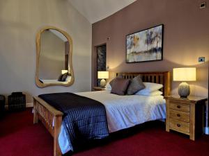 a bedroom with a large bed with a large mirror at The Badger Inn in Church Minshull