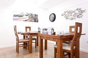 a dining room with two tables and a clock on the wall at Avon Beach Bed & Breakfast in Christchurch