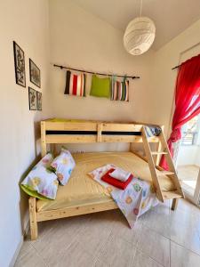 Litera de madera en habitación con ventana en Nikiti Azzurro villa, en Nikiti