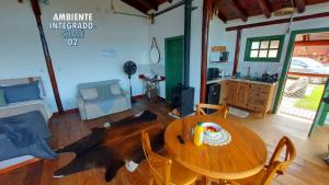 ein Wohnzimmer mit einem Holztisch und Stühlen in der Unterkunft Chalé Luz do Luar Romantismo e uma linda vista in Campos do Jordão