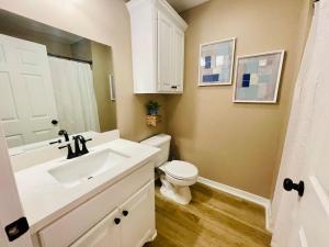 a bathroom with a white sink and a toilet at Eastgate 18A beautiful townhouse in Hammond +35 photos