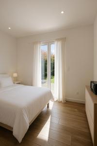 a bedroom with a bed and a large window at Jolie villa avec piscine in Monticello