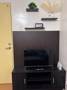 a flat screen tv sitting on top of a black entertainment center at Seawind Condominium in Davao City