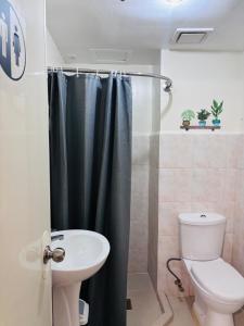 a bathroom with a shower with a toilet and a sink at Seawind Condominium in Davao City
