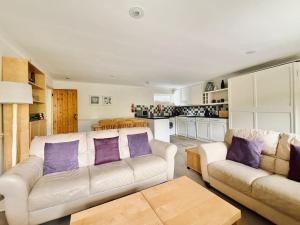 a living room with two white couches and purple pillows at 2 Bed Apartment with Shared Pool in Kingsbridge