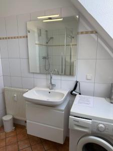 ein Badezimmer mit Waschbecken und Waschmaschine in der Unterkunft Friedensstraße 43 Wohnung 7 in Zingst