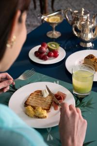 a woman sitting at a table with a plate of food at Palace Hotel in Viareggio