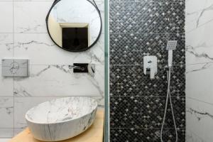 a bathroom with a large marble tub and a mirror at Dimitreli Venetia Studios in Koinyra