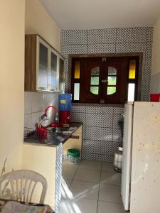 a kitchen with a sink and a refrigerator at Casa aconchegante in Barra de Santo Antônio