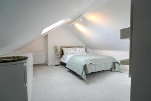 a white bedroom with a bed in a attic at Parkside View, Exeter in Alphington