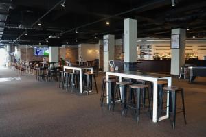 a row of bar stools in a large room at SOPO Backpackers in Gold Coast