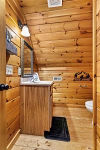 un bagno in stile baita di tronchi con lavandino e specchio di Private Lake Hot Tub Fire Pit 5 Min to Hollerwood a Campton Altre 42 foto