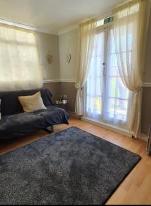 a living room with a couch and a large window at Animal friendly Sea 2 mins away in Trusthorpe
