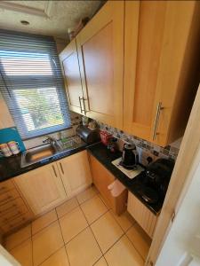 a kitchen with wooden cabinets and a black counter top at Animal friendly Sea 2 mins away in Trusthorpe