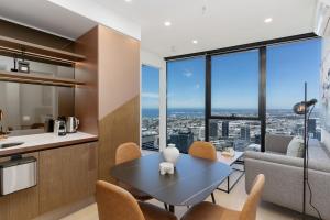 Una cocina y una sala de estar con mesa y sillas. en Perfect Escape Wake Up to Stunning Harbour Views, en Melbourne