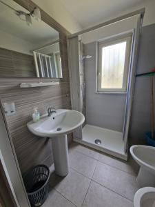 a bathroom with a sink and a shower at Casa Alba Paestum in Paestum +21 photos
