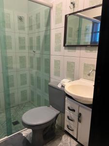 Un baño con inodoro, lavabo y ducha. en Quarto suite em Caraguatatuba, en Caraguatatuba
